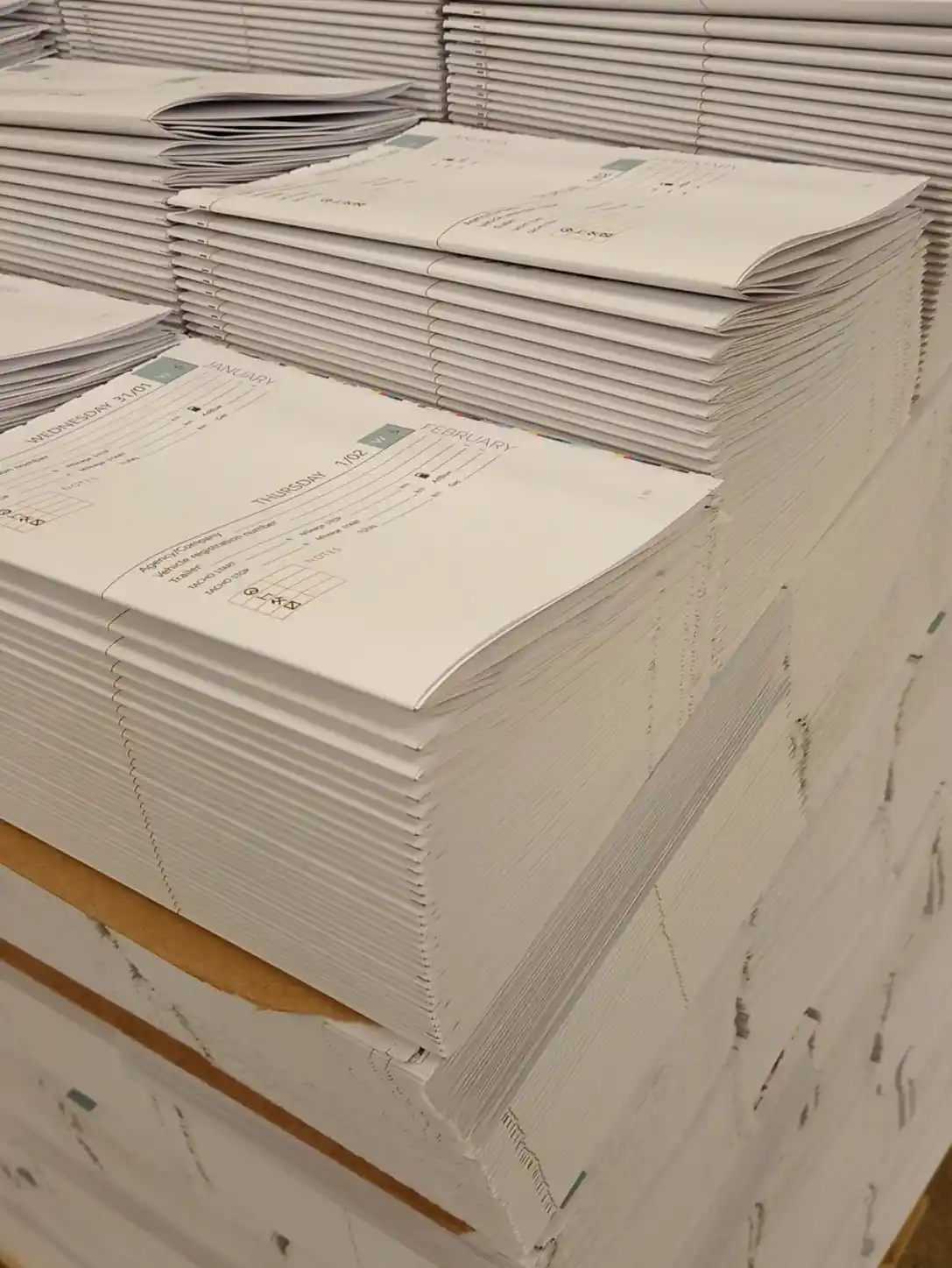 Gefalzte Druckbogen und gestapelte Innenseiten zur Herstellung unserer Fahrerkalender.