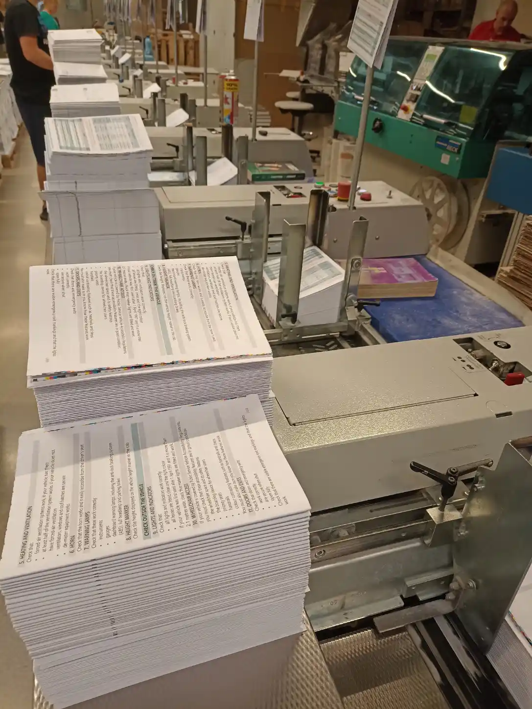 Gedruckte Kalenderbogen an einer Maschine zur Weiterverarbeitung in der Buchbinderei.
