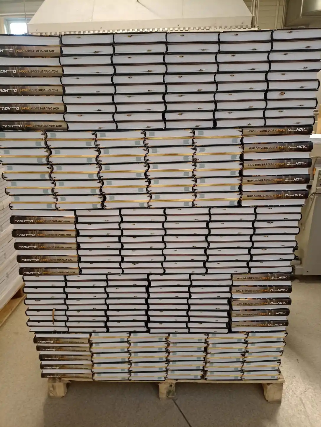 Fertig gebundene HGV Drivers Diary Kalender einer früheren Auflage, gestapelt auf einer Palette in der Druckerei.
